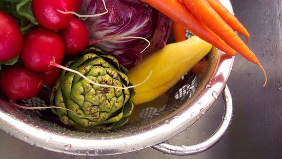 Freshly washed vegetables in a colander.