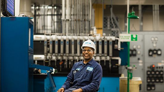Man sitting down and smiling in power plant - Ecolab